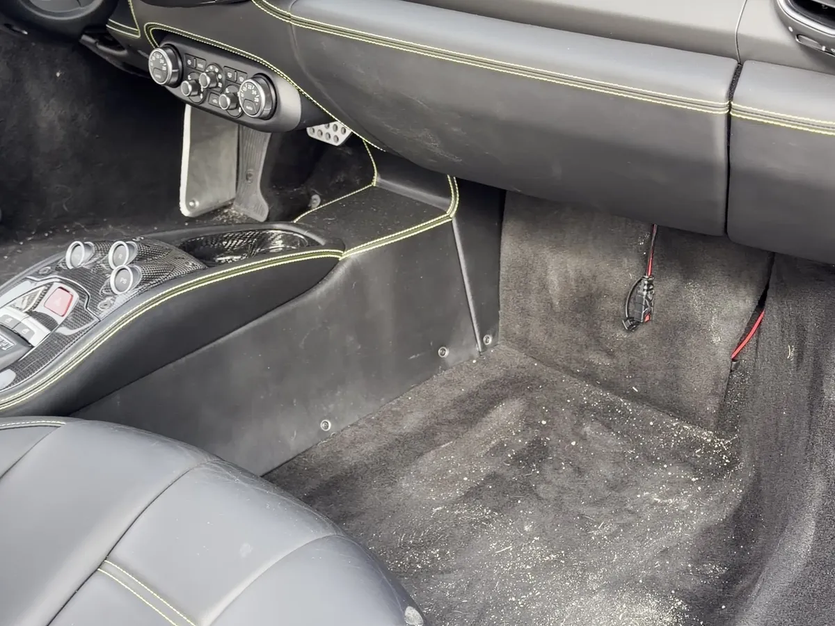 Ferrari 458 Italia passenger footwell with dust and debris before detailing