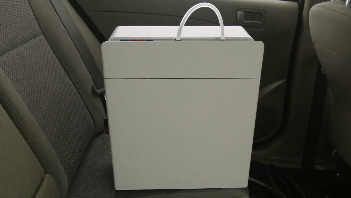 Ozone generator running on the back seat of a car during odor treatment